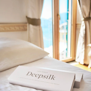 OPSUNDBAY Deepsilk-pude og gaveæsker på et hotelværelse.