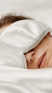 Resting woman wearing the OPSUNDBAY Deepsilk Sleeping Mask, enjoying uninterrupted sleep. Made from soft 25 momme Mulberry silk, the mask features a comfortable fit, providing complete darkness while being gentle on the skin, ensuring a deep and restful REM sleep.